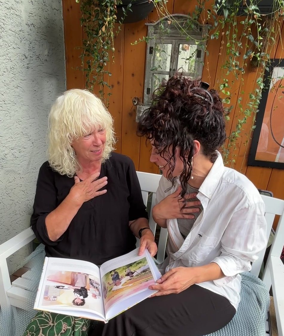 Marjella and her daughter reading their finished personalised book Who is Nana? together, both visibly moved